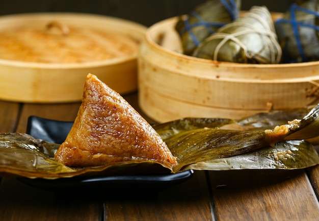 Reisknödel Zongzi und Bambusdämpfer auf Holztisch