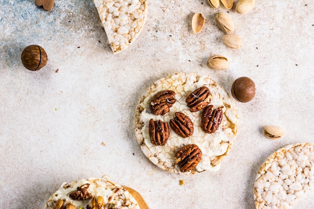 Reiskuchen mit Honig und Nüssen. Gesundes Frühstück. Macadamianüsse mit Honig. Vegetarisches Frühstück. Süßes Frühstück von oben. Reis-Dessert. Gesundes Weihnachtsdessert,