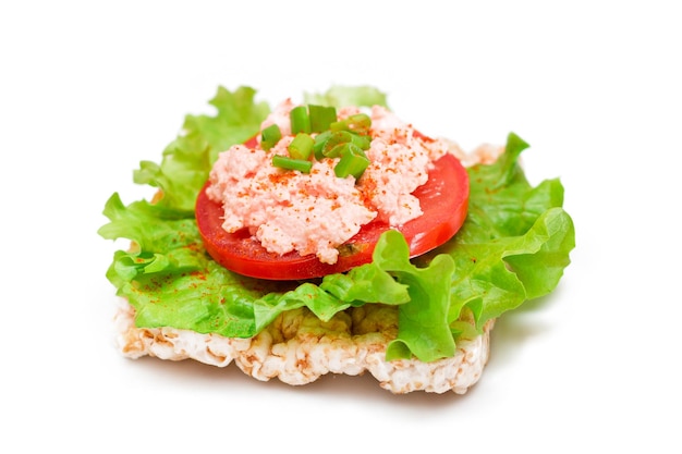 Reiskuchen-Sandwich mit Tomatensalat, Fischcreme und Frühlingszwiebeln isoliert