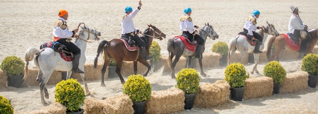 Reiter, der in ihrer ethnischen Kleidung auf Pferd reitet