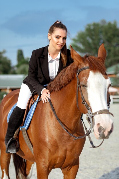 Reiter elegante Frau, die draußen ihr Pferd reitet