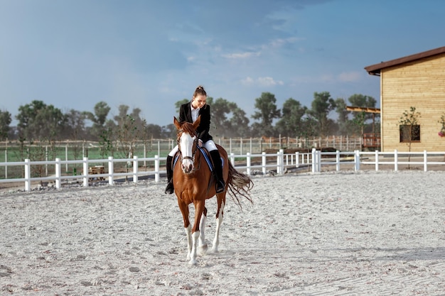 Reiter elegante Frau, die draußen ihr Pferd reitet