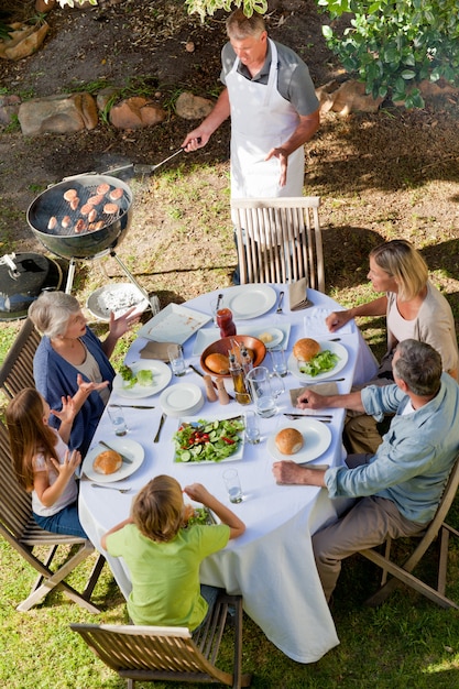 Reizende Familie, die im Garten isst