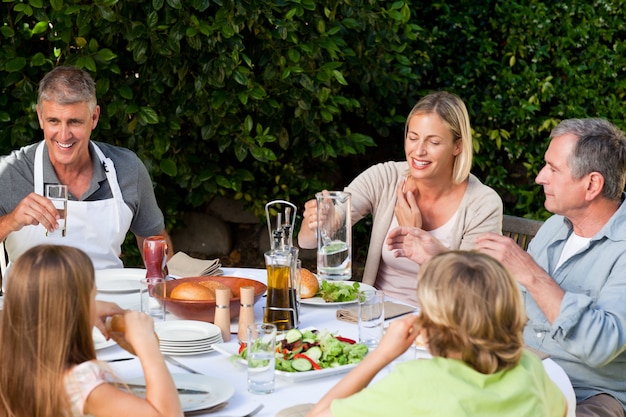 Reizende Familie, die im Garten isst