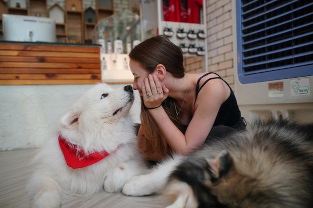 Reizende junge Frau, die mit ihrem Hund spielt