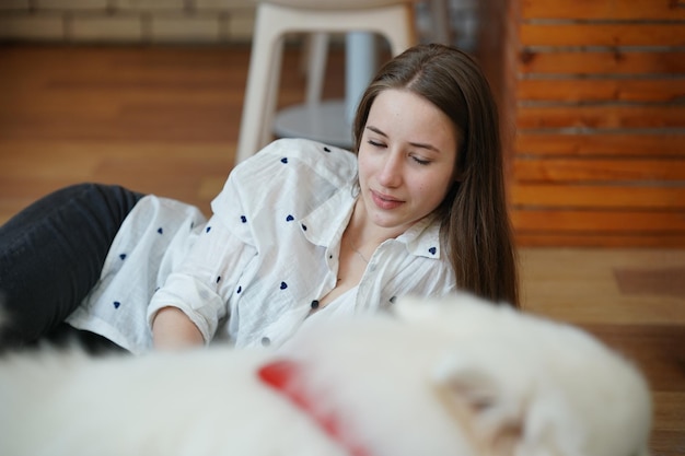 Reizende junge Frau, die mit ihrem Hund spielt