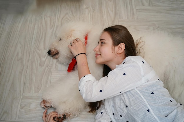 Reizende junge Frau, die mit ihrem Hund spielt