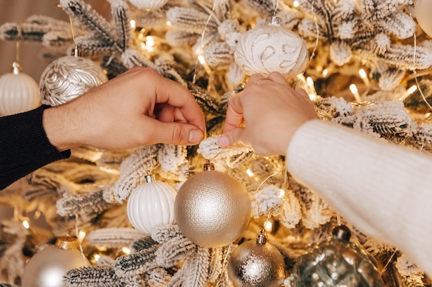 Reizendes junges romantisches Paar, das Weihnachtsbaum küsst und umarmt, gemütliche Innenatmosphäre