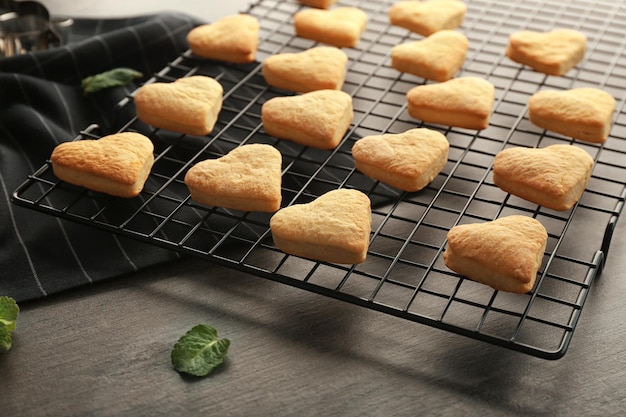 Rejilla para hornear con galletas de mantequilla en forma de corazón en la mesa