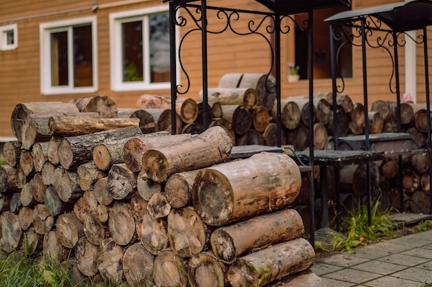 Rejilla de madera por el lugar de barbacoa de hierro junto a la imagen de la casa de campo con enfoque selectivo