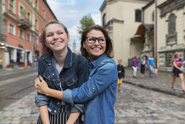 Relação pai e adolescente, abraçando sorridente mãe e filha