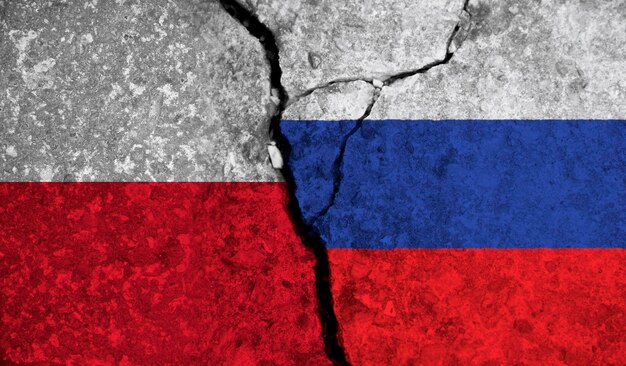Relação política entre bandeiras nacionais da polônia e da rússia em fundo de concreto rachado