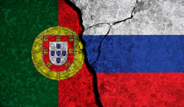 Relação política entre bandeiras nacionais de portugal e rússia em fundo de concreto rachado