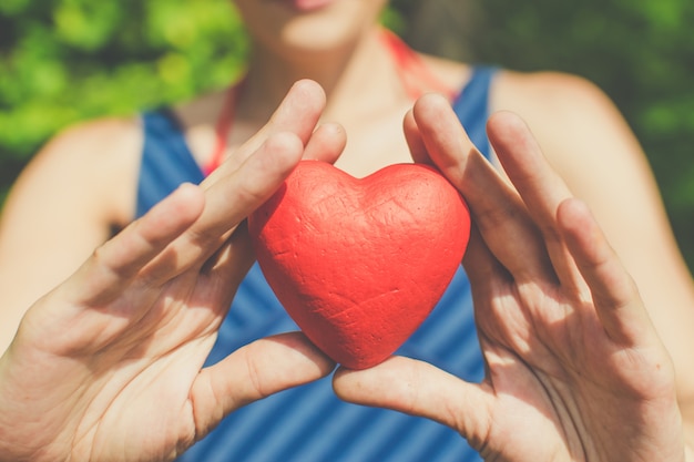 Relación y amor manos de mujer sosteniendo corazón rojo