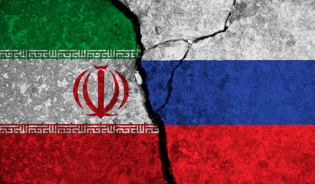 Relación política entre las banderas nacionales de irán y rusia sobre fondo de hormigón agrietado