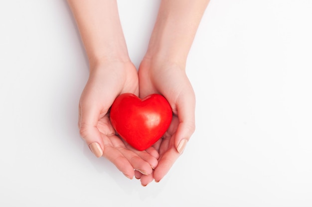 Relacionamento de pessoas e conceito de amor perto das mãos em concha da mulher mostrando coração vermelho