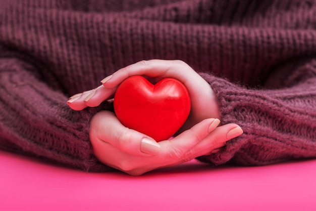 Relacionamento de pessoas e conceito de amor perto das mãos em concha da mulher mostrando coração vermelho