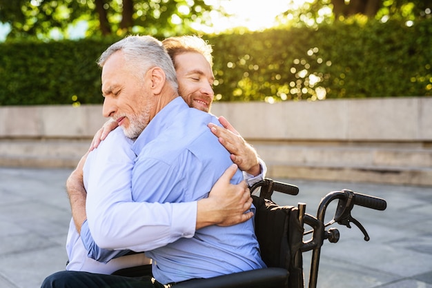 Relaciones familiares. Hijo abraza feliz viejo.