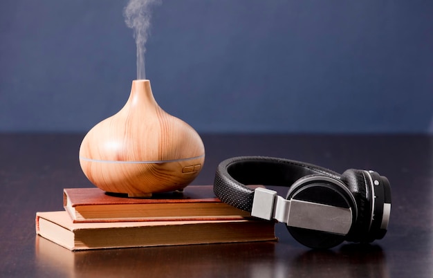 Foto relajación en casa con difusor de aceite de aromaterapia y auriculares con libro aroma esencia de salud