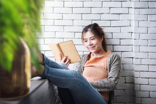 Relajación con el concepto de libro. Mujer joven que pasa tiempo leyendo en casa acogedora