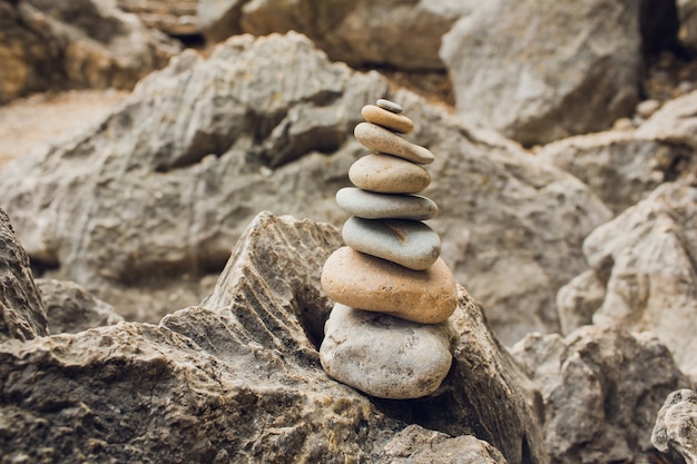 Relajación de meditación zen: imagen de estilo hipster filtrado de efecto retro vintage de pila de piedras equilibradas con flor de plumeria frangipani de cerca en la playa del mar.