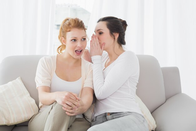 Relajado amigas chismeando en la sala de estar