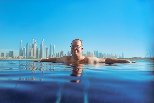 Relajado hombre pelirrojo caucásico europeo en la piscina en Dubai