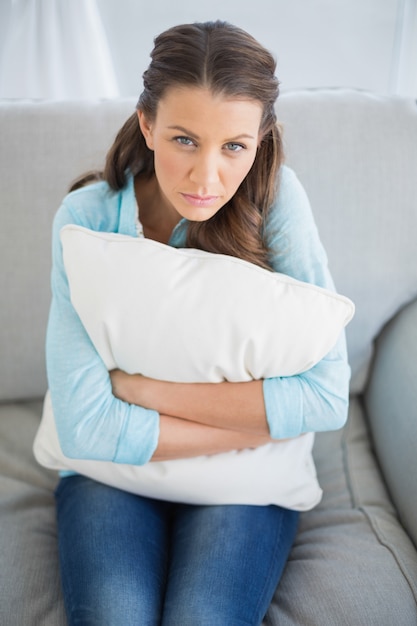 Relajado mujer sentada en el sofá con almohada