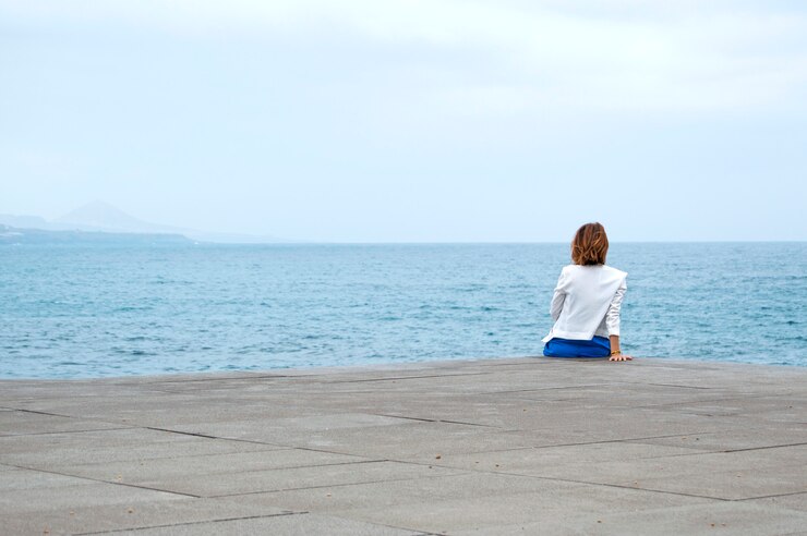 Relajado y sentado mirando el horizonte.
