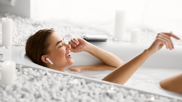 Foto relajarse en el baño mujer disfrutando de la música en el baño