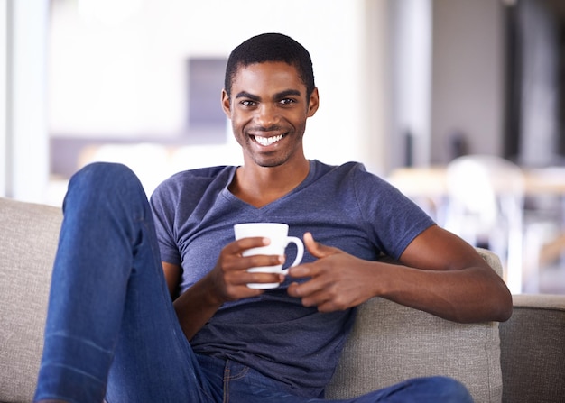 Relajarse con una buena taza de té Captura recortada de un apuesto joven relajándose con una taza de café