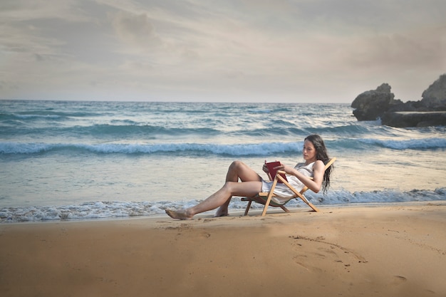 Foto relajarse y leer en la playa.