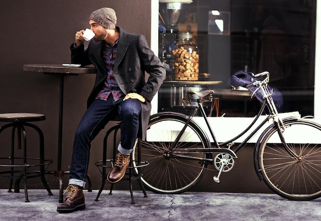 Relájese café y hombre con una bicicleta de café y moda en la ciudad sostenible y huella de carbono Persona masculina y ciclista con té en la calle y al aire libre con bicicleta y transporte ecológico