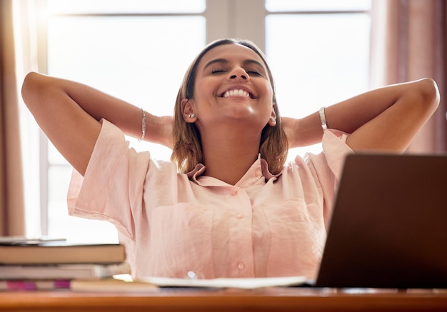 Relájese estudiante y mujer con los ojos cerrados en casa después de estudiar y terminar el proyecto de investigación beca de educación en reposo o sonrisa de mujer feliz y tranquila después de completar la tarea de aprendizaje en casa