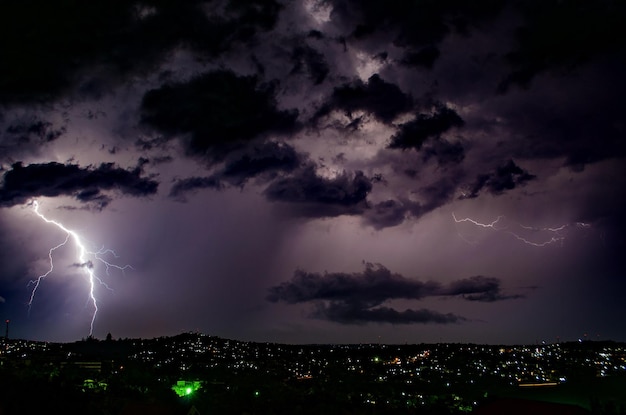 Foto relámpago en el cielo sobre la ciudad por la noche