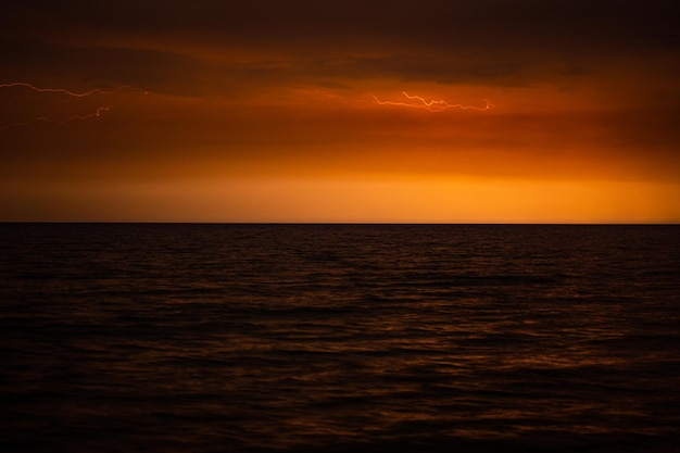 Los relámpagos iluminan el cielo por la noche en el mar.