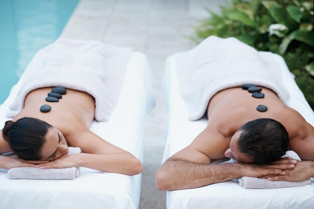 Relaxamento de paz e alguém para amar foto recortada de um casal desfrutando de uma massagem com pedras quentes