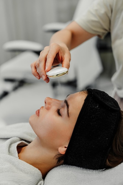 Relaxamento e cuidados com a pele se misturam quando uma mulher desfruta de um tratamento facial num spa tranquilo