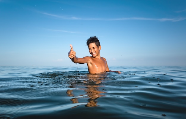 Relaxamento e estilo de vida saudável. adolescente jovem se banha no mar.