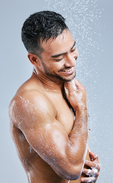 Relaxando os músculos com um banho quente Foto de estúdio de um jovem bonito tomando banho contra um fundo cinza