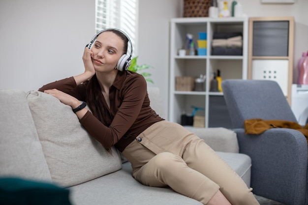 Relaxando ouvindo música em fones de ouvido enquanto está sentado em um sofá macio