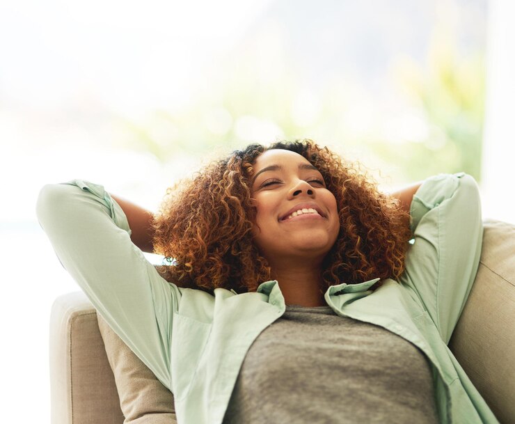 Foto relaxar-se em casa e mulher no sofá sorrir e descansar com férias de fim de semana sesta à tarde e despreocupado na sala de estar apartamento pessoa ou menina no sofá refrescante ou bem-estar com sonho acordado e sol