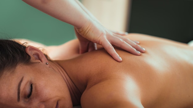 Relaxe a massagem para os ombros mãos de um massoterapeuta massageando o ombro de uma cliente do sexo feminino