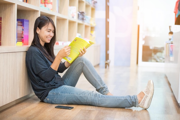 Relaxe a mulher asiática lendo livro sentado no sofá na sala segurando o livro para ler jovem leitor de relaxamento lendo livro aberto mente de lazer felicidade beleza mulher pessoa rosto sorridente tempo feliz