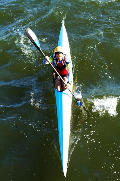 Relaxe a viagem e o caiaque com o homem no rio para uma viagem de férias verão e esportes aquáticos de cima Natureza saúde e paz com caiaque masculino remando em canoa para competição de fitness e corrida