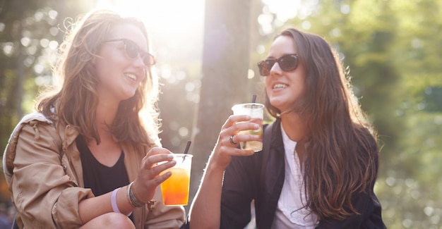 Foto relaxe mulheres e amigos com bebidas ao ar livre e felicidade para unir tempo de qualidade e aplausos pessoas do sexo feminino, meninas e senhoras, bebendo ao ar livre e comemorando com alegria, evento alegre e social