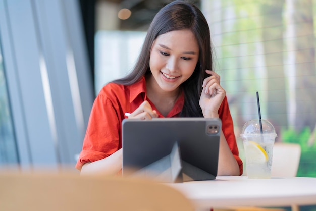 Relaxe o sorriso do empreendedor freelance feminino asiático inteligente atraente de lazer e divirta-se trabalhando com smartphone e laptop no café com conceito de ideias casuais de nômade digital de negócios de cidade borrada