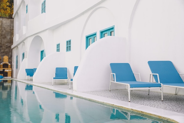 Relaxsessel am Pool mit weißen Art-déco-Gebäuden