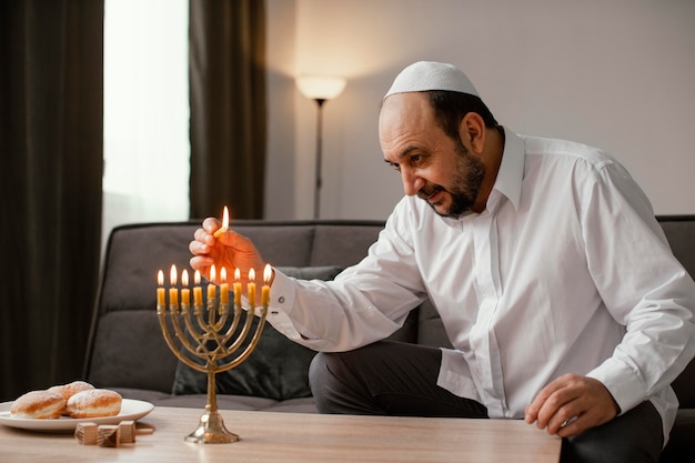 Foto religiöser mann, der eine kerze anzündet