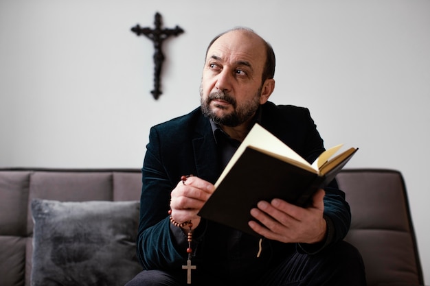 Religiöser Mann, der zu Hause ein heiliges Buch liest